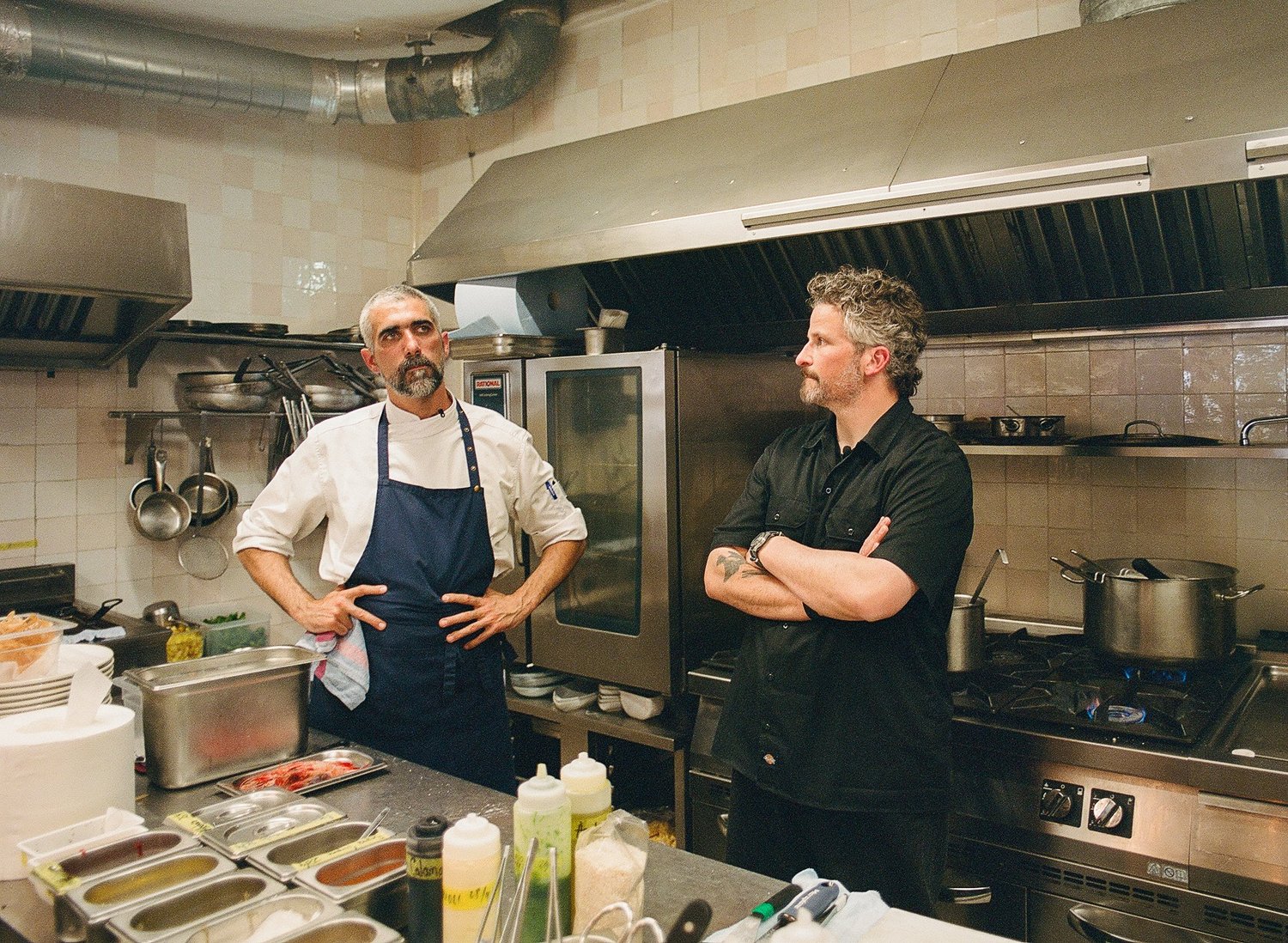 Le chef en tablier bleu et un homme en cuisine avant le service, Casa Pregonda