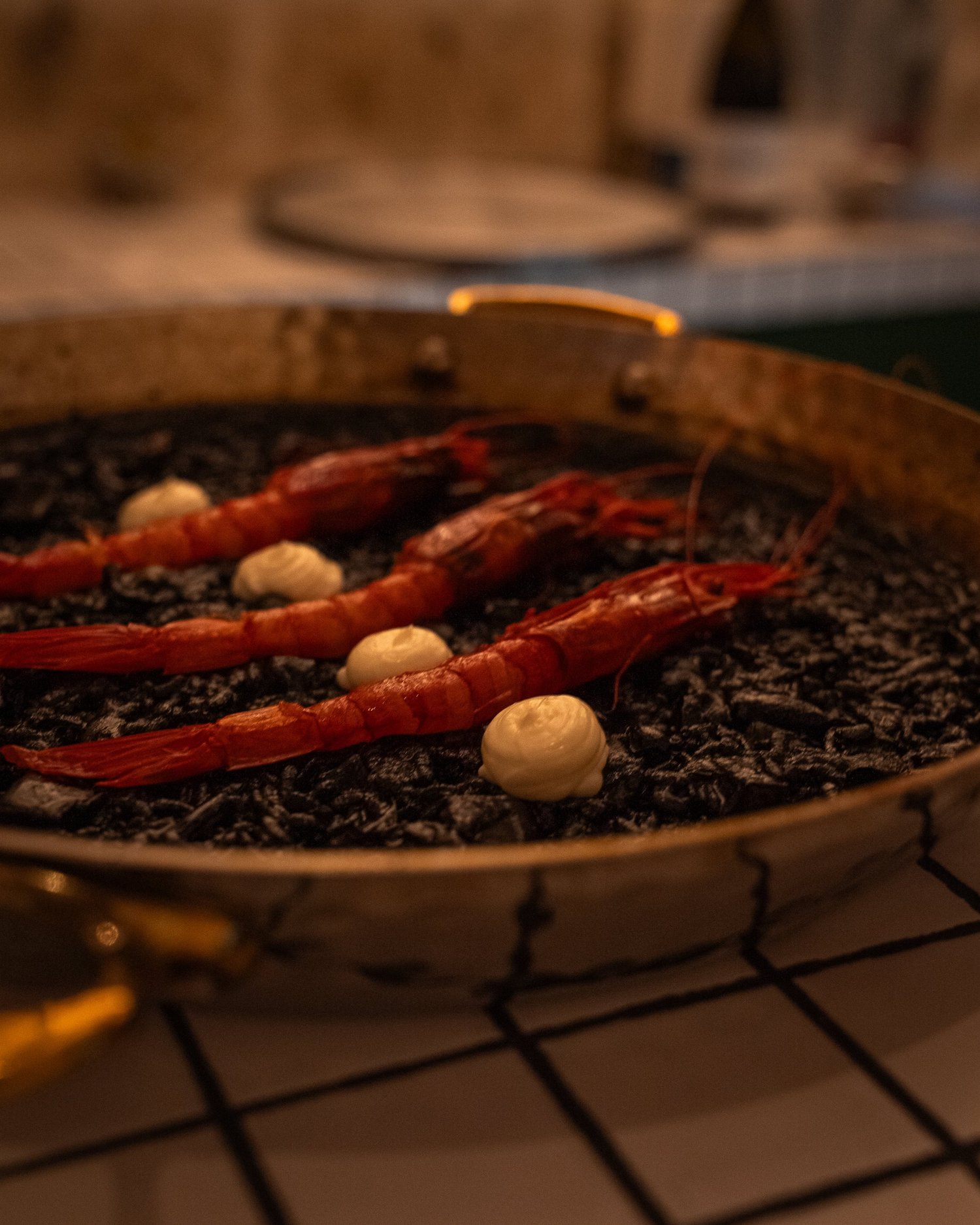Riz à l'encre de seiche et gambas dans sa paella, plat signature de Casa Pregonda, Paris