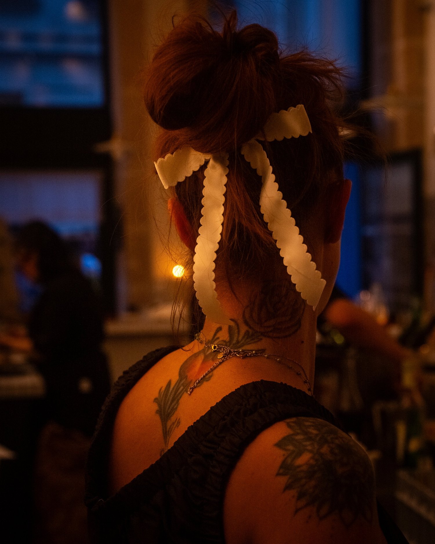 Une serveuse de dos, rubans dans les cheveux, pendant le service chez Casa Pregonda, Paris