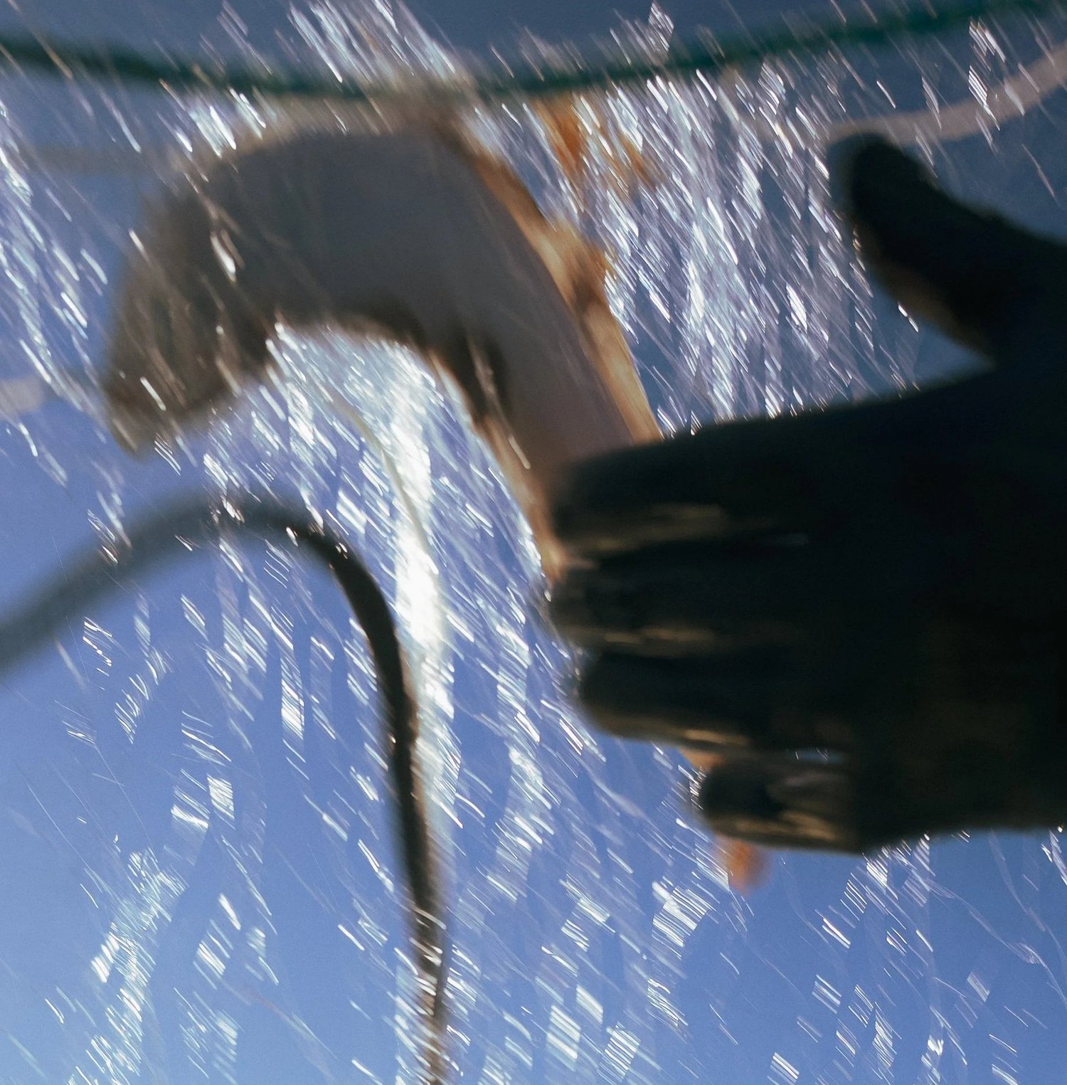 Gerbe d'eau et main gantée au-dessus du bastingage, image floue prise pendant la manoeuvre