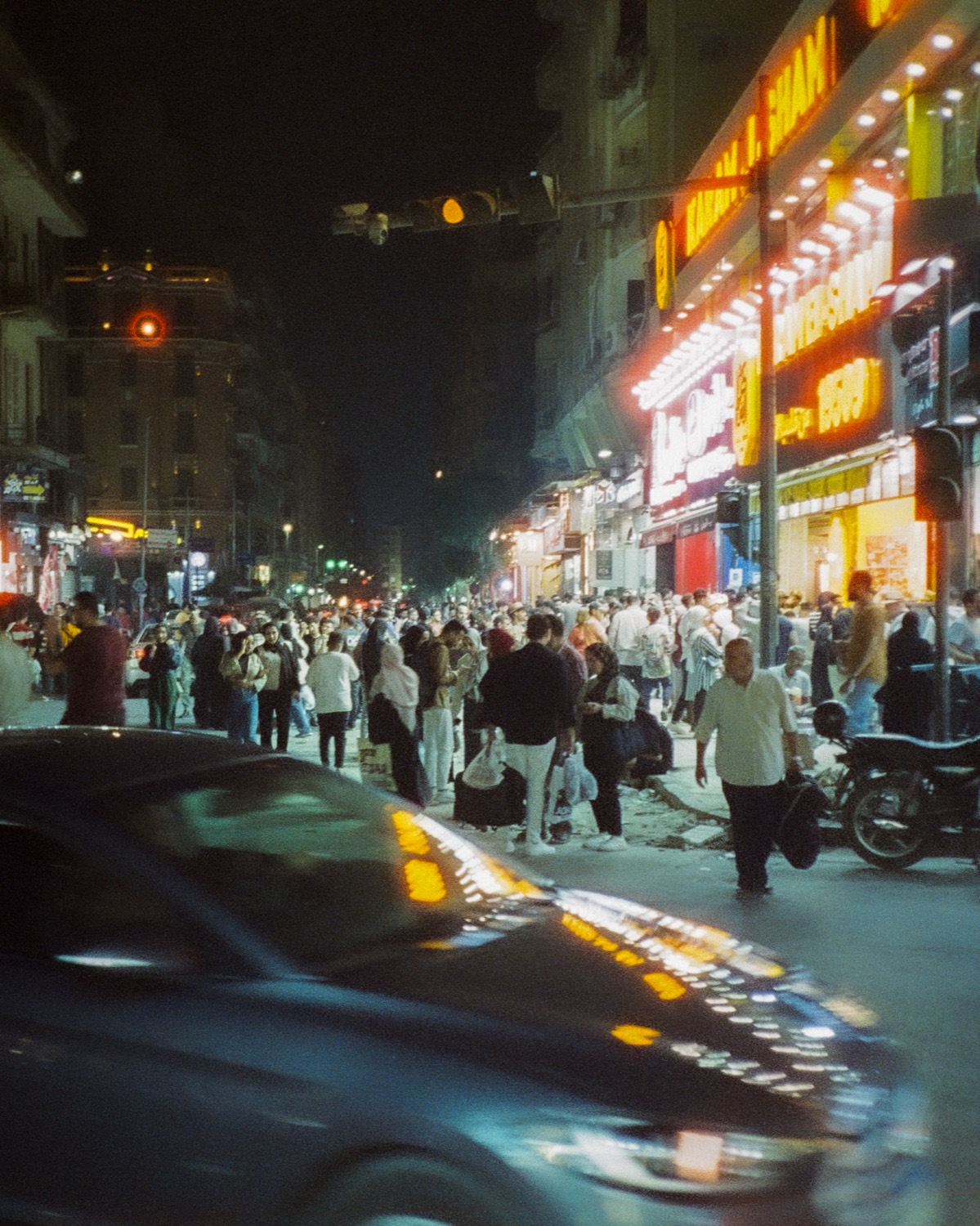 Foule et enseignes lumineuses dans une avenue du Caire, la nuit