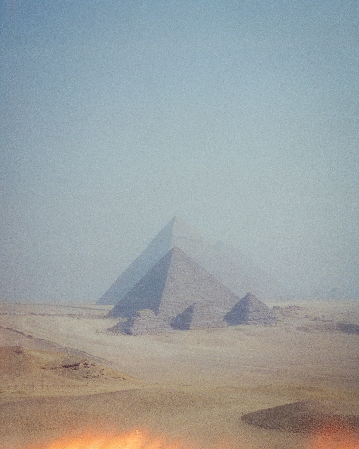 Les pyramides de Gizeh dans la brume de chaleur, au bout du désert