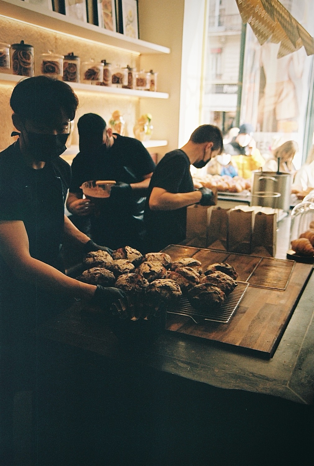 Les pâtissiers dressent les cookies sur la grille derrière le comptoir, Cédric Grolet, Paris
