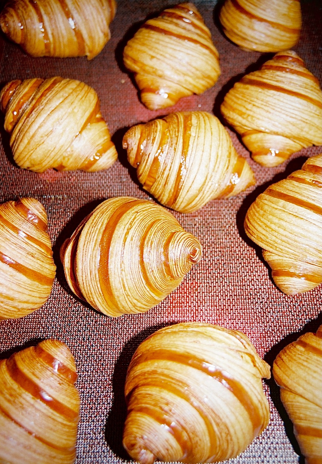 Croissants dorés et brillants alignés sur la plaque à la sortie du four, Cédric Grolet, Paris