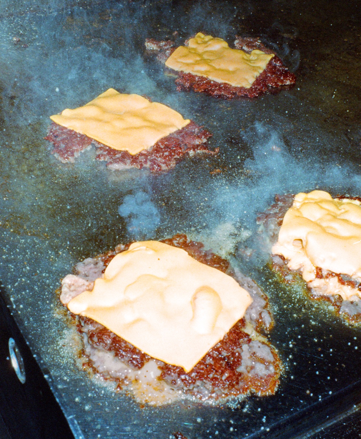 Quatre steaks smash coiffés de cheddar fondant sur la plancha, Howard Original