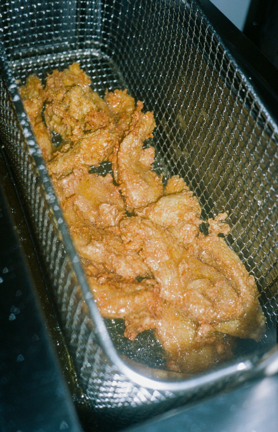 Beignets de poulet dorés dans le panier de friteuse, cuisine de Howard Original