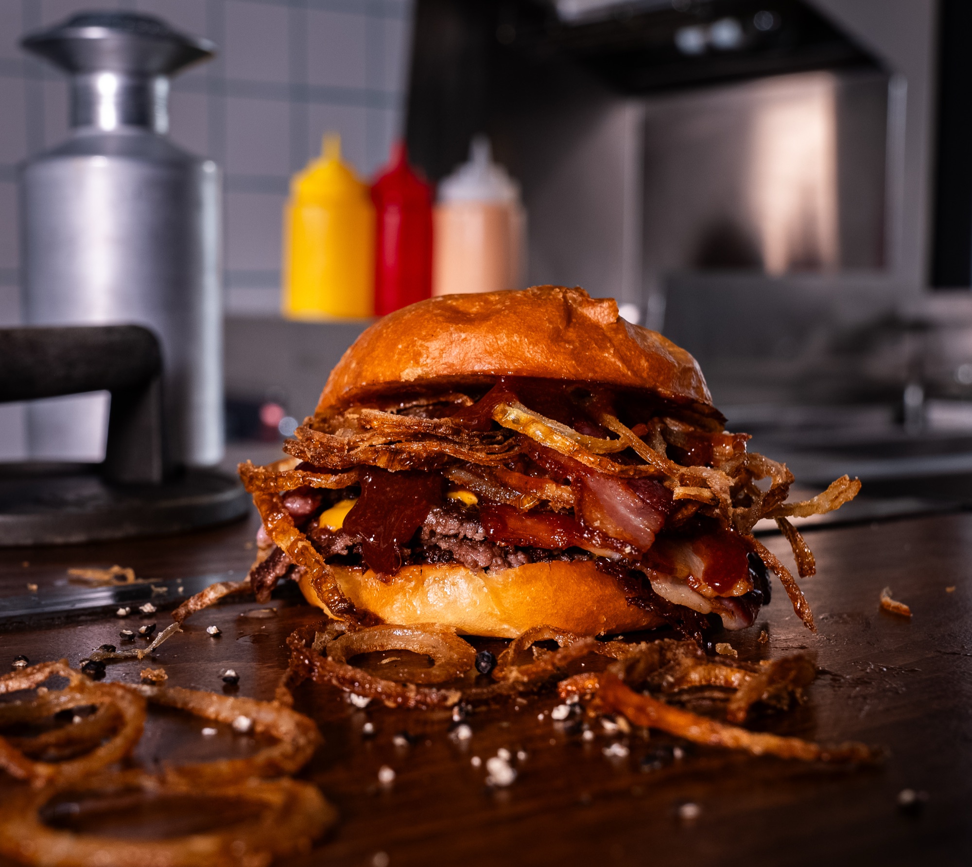 Burger au bacon et aux oignons frits croustillants posé sur le plan de travail, Howard Original