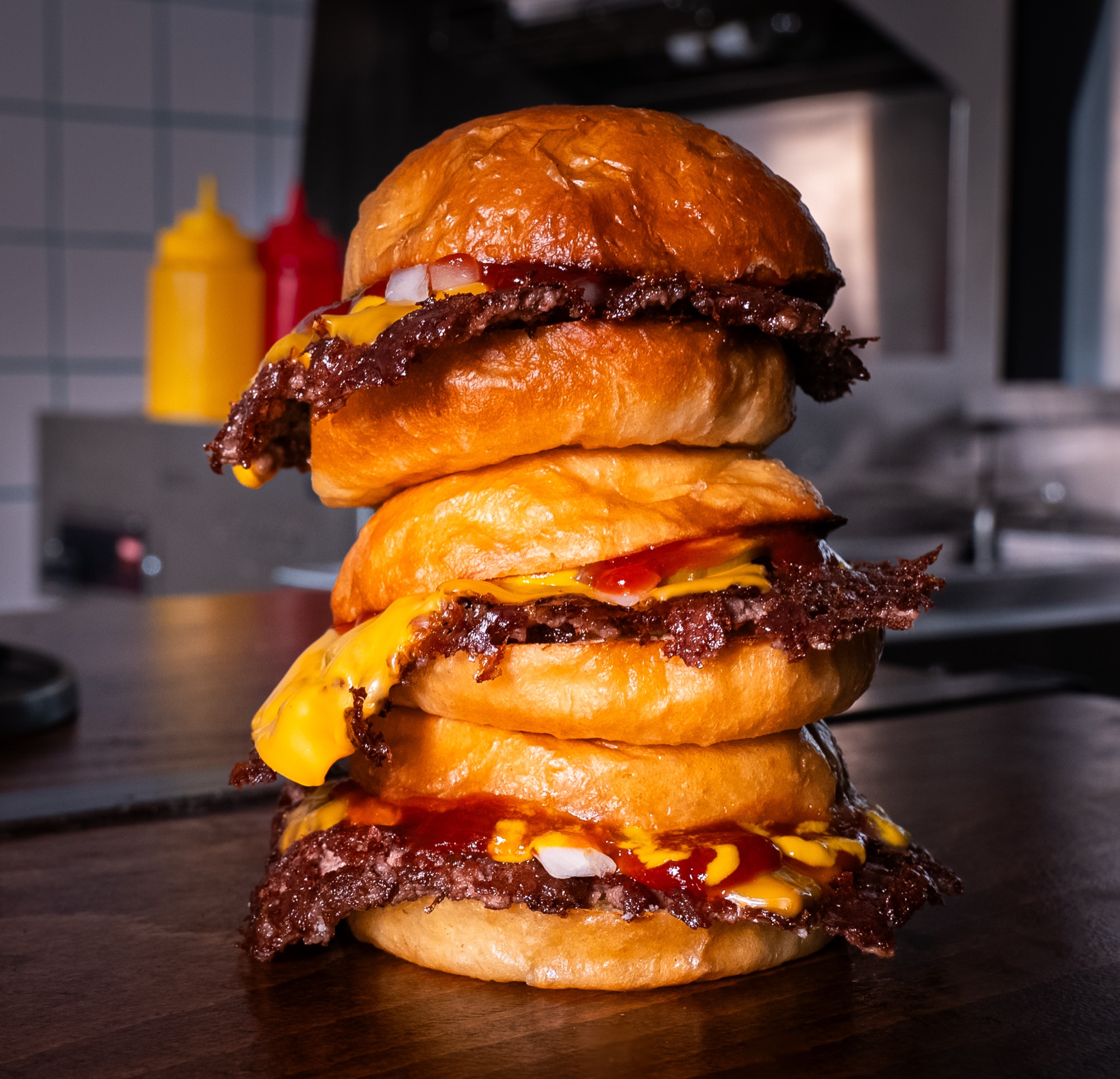 Trois cheeseburgers empilés en tour devant les fourneaux, Howard Original