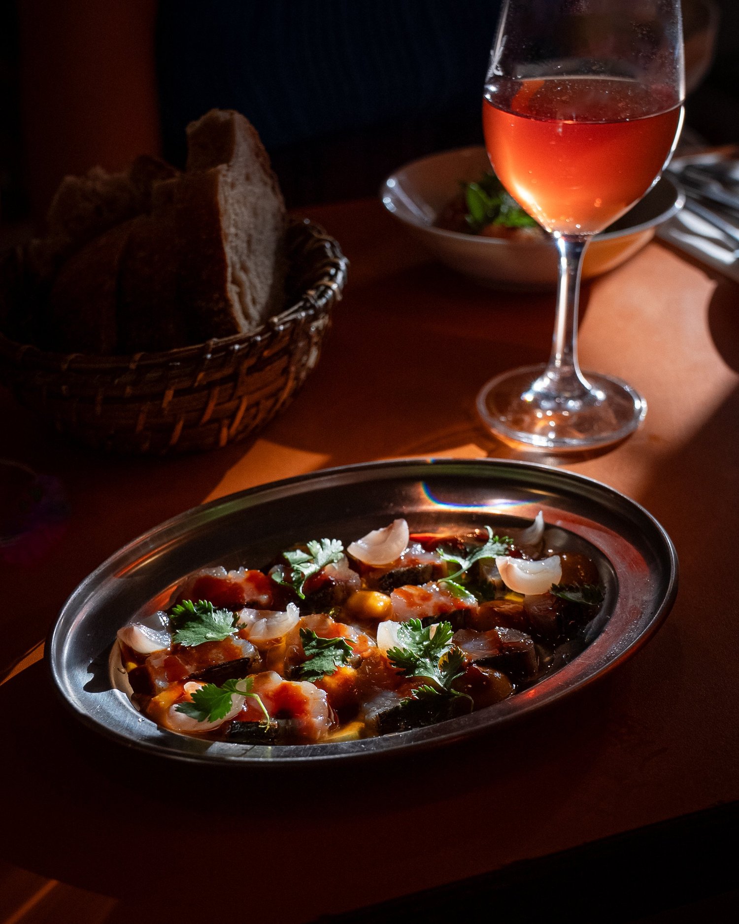 Plat de poisson mariné aux herbes, corbeille de pain et verre de rosé, Livingston, Marseille