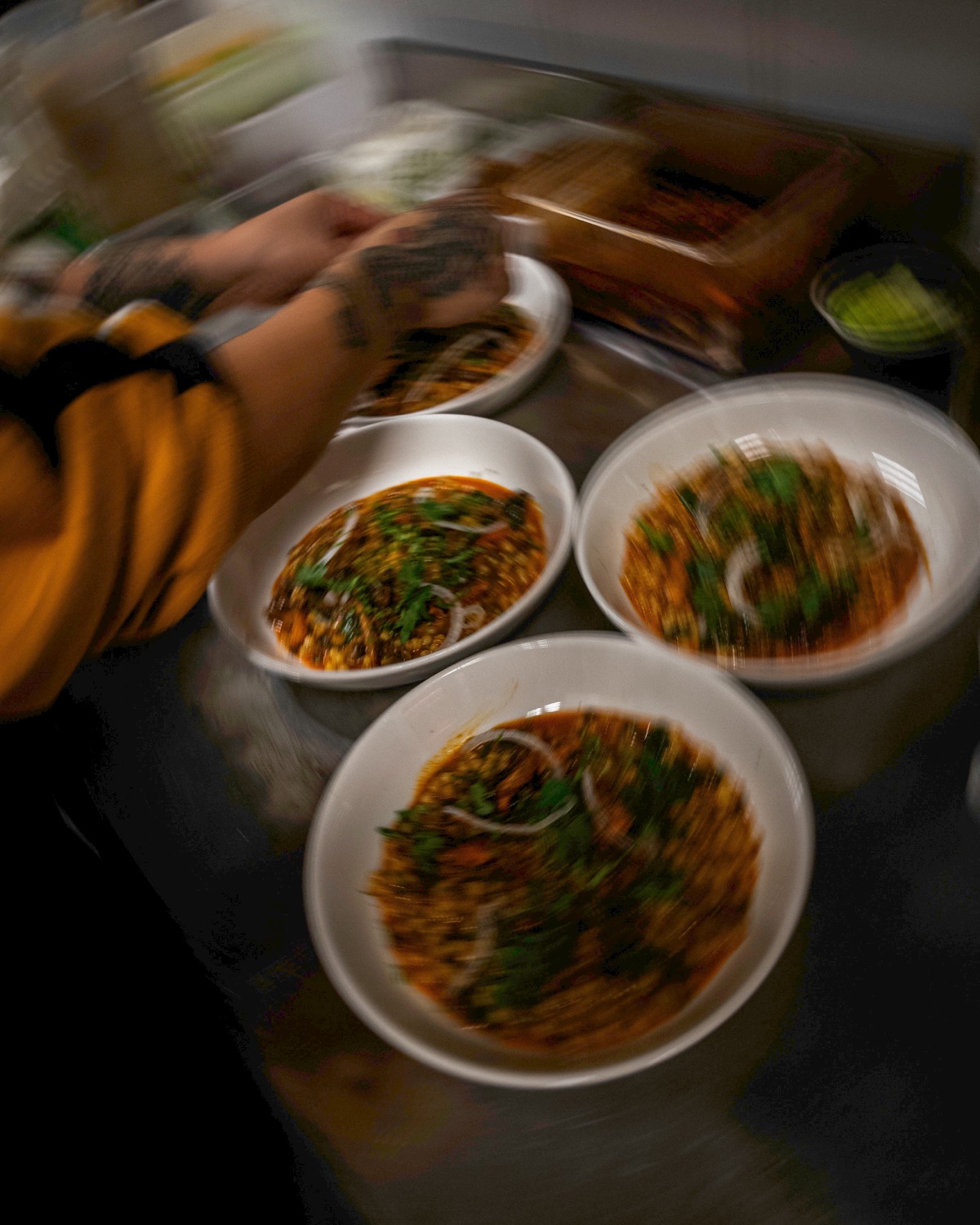 Un cuisinier dresse des assiettes de légumes en sauce, image saisie en mouvement, Livingston