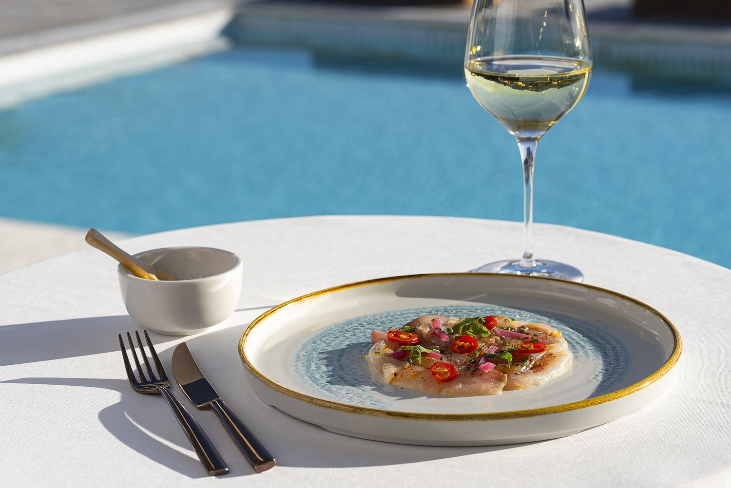Ceviche et verre de blanc dressés au bord de la piscine, restaurant du Nhow à Marseille