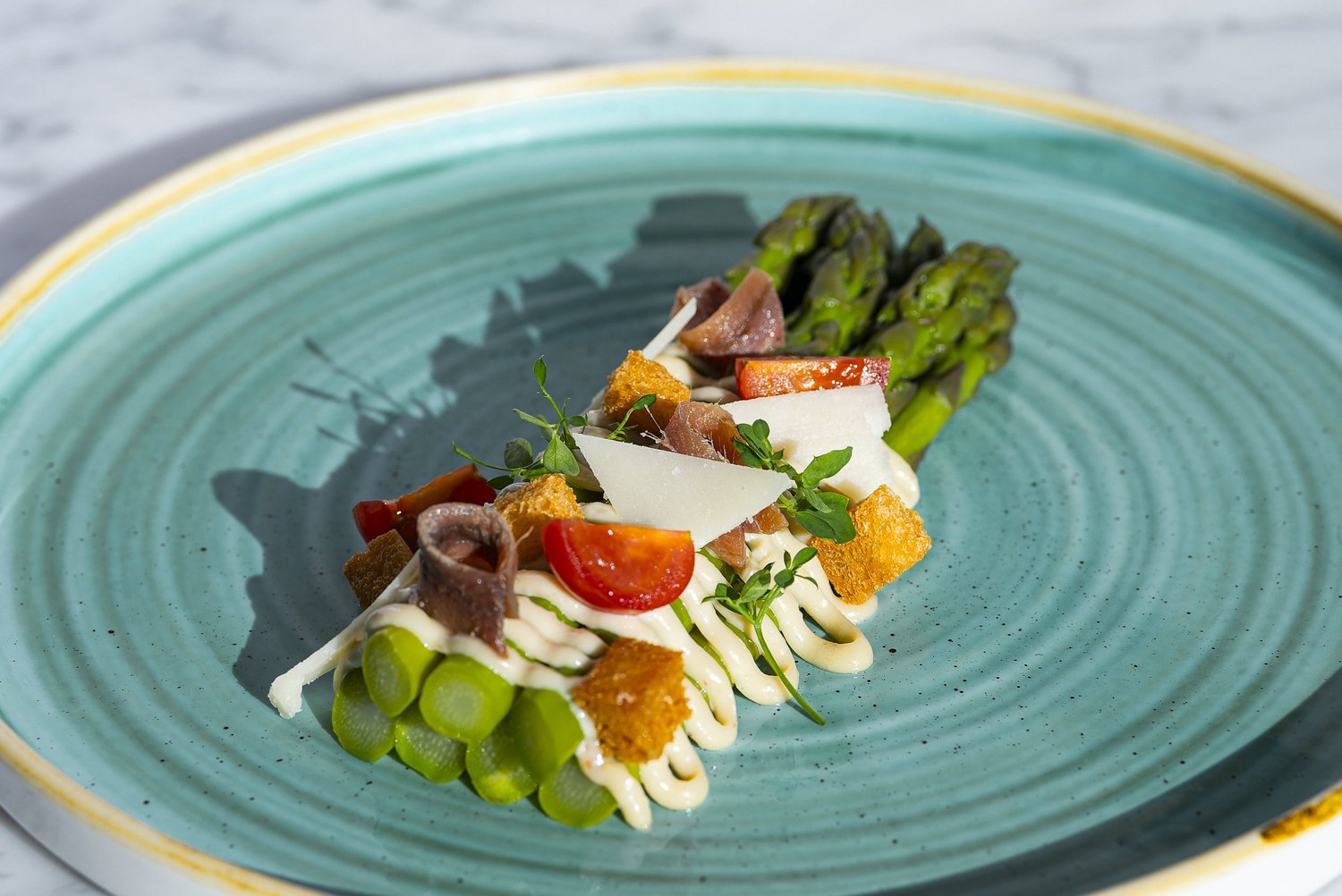 Asperges vertes, anchois, tomates et croûtons sur assiette vert d'eau, Nhow, Marseille