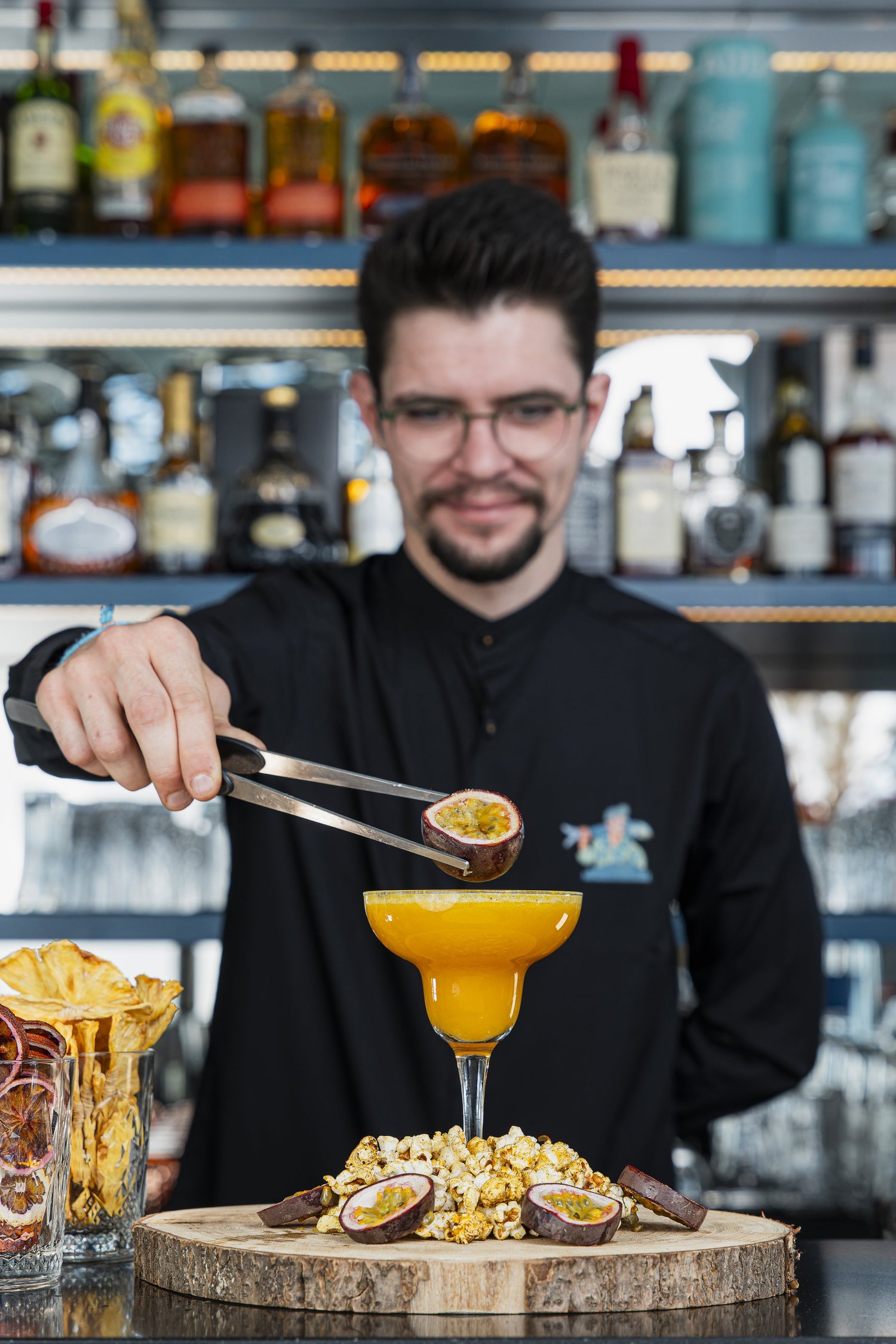 Le barman dépose un fruit de la passion sur un cocktail à la pince, bar du Nhow, Marseille
