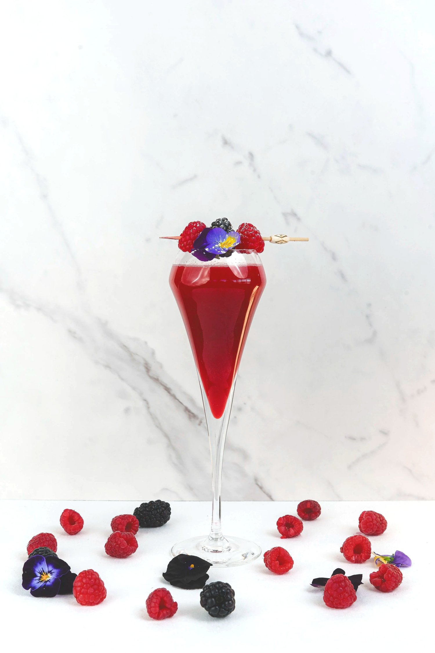 Cocktail rouge aux fruits rouges et fleur comestible sur fond de marbre, bar du Nhow, Marseille