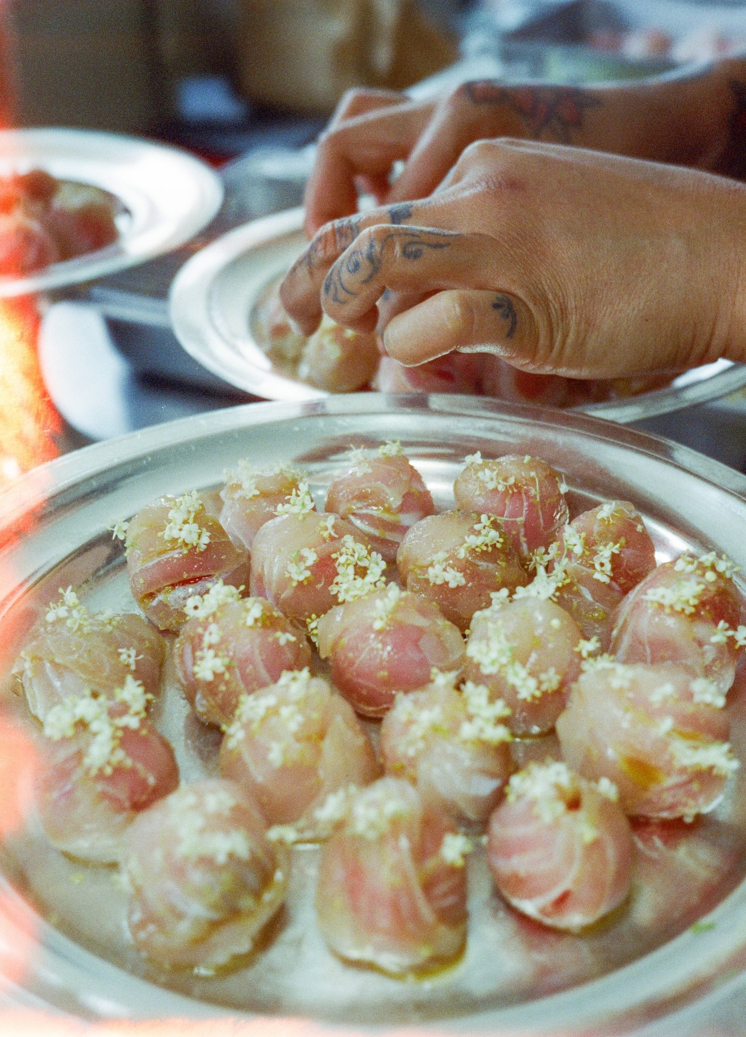 Bouchées de sériole marinée et fleurs de sureau sur plateau d'argent, dîner Chanel de Valentin Raffali