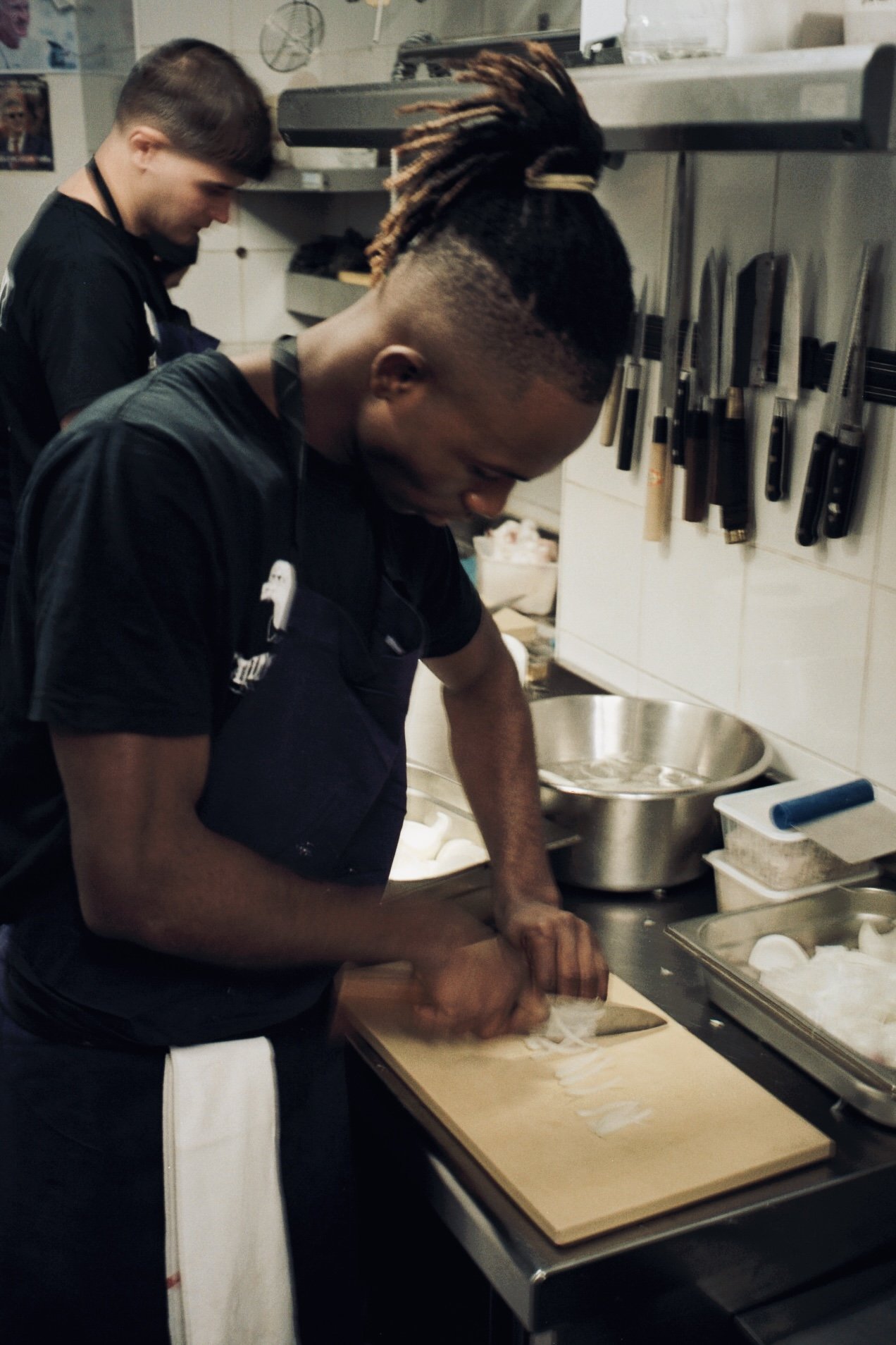 Deux cuisiniers au travail sous la barre à couteaux, cuisine du restaurant