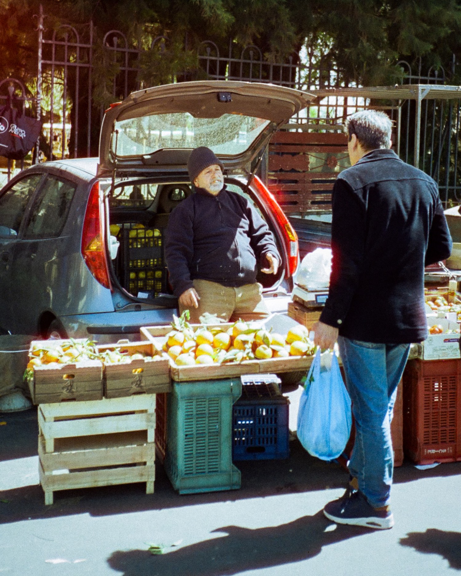 Un maraîcher vend ses agrumes depuis le coffre de sa voiture, marché de rue en Sicile